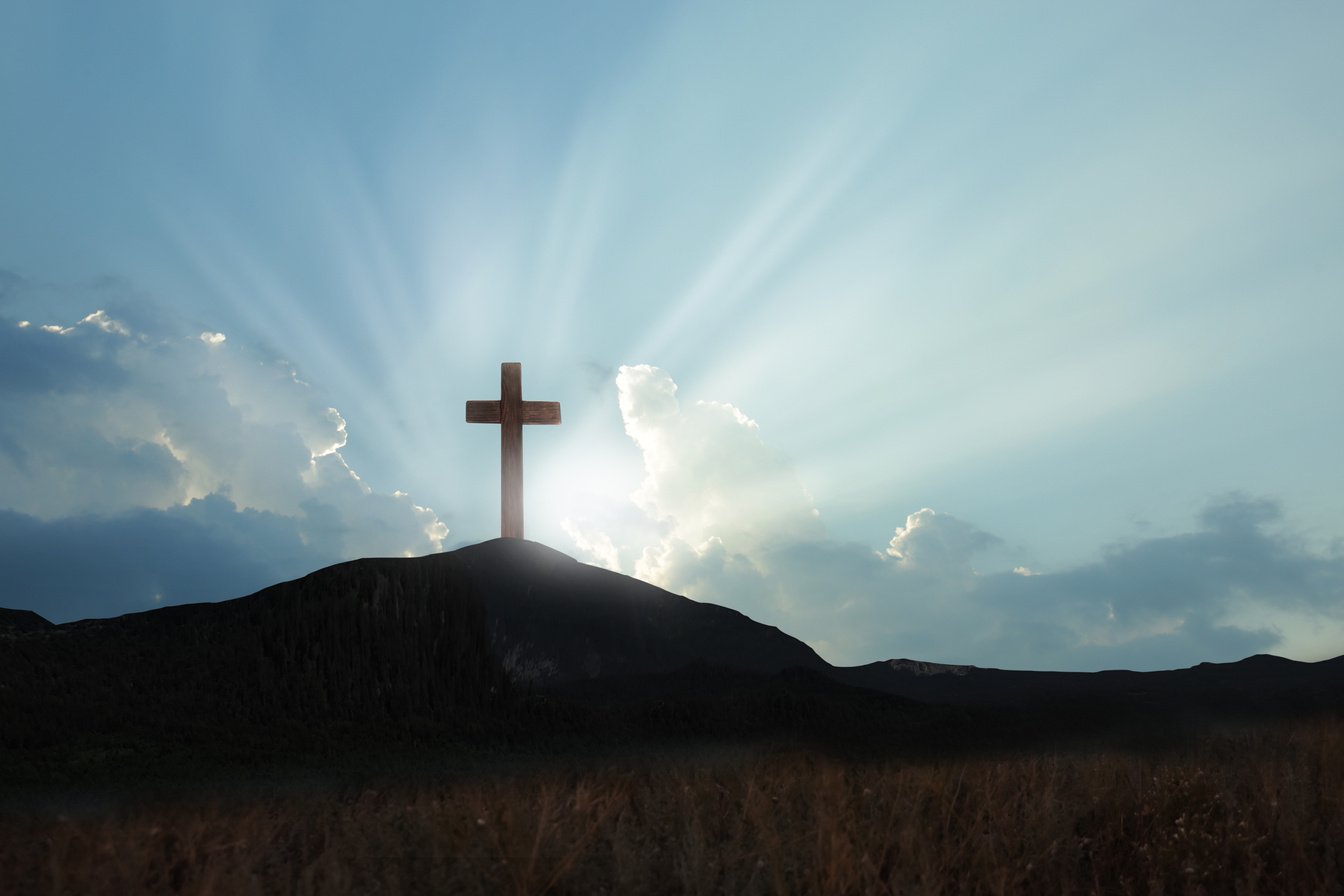 Christian cross on hill outdoors at sunrise. Resurrection of Jesus